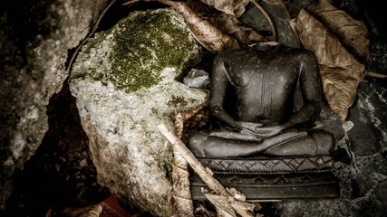 A headless statue of a person on rock