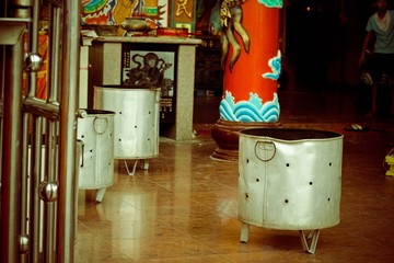 A metal pot with holes sat on ground