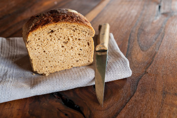 Fresh crisp bread with caraway on wooden table and knife