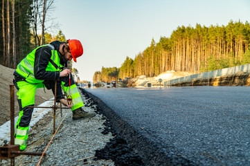 Surveyor engineer with equipment (theodolite or total positioning station) on the construction site...
