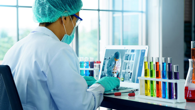 Scientist are experiment with science on vaccines to treat Coronavirus. Analysis meeting through video conference with a laptop. Working in a lab or Hospital. Concept work at home and new normal - Powered by Adobe