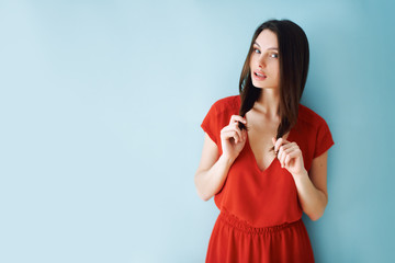 studio portrait of a girl in a red dress. brunette hair