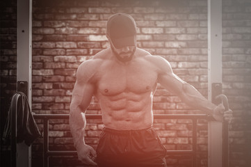Fototapeta na wymiar strong sport young bearded man in sportswear during outdoor street training workout on brick wall background