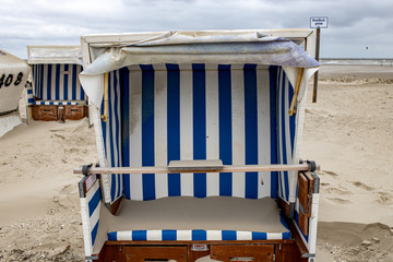 Versandeter leerer Strandkorb in Norddeutschland am Strand, Regenwetter