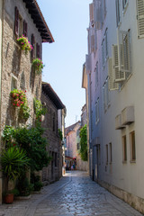 Narrow alley with colorful croatian houses in the old town of Porec (Parenzo), Croatia