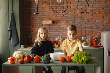 Brother and sister. Children prepare the salad. Kids in the kitchen.