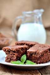 Gingerbread cakes with leaves of mint. Jug of milk in background.