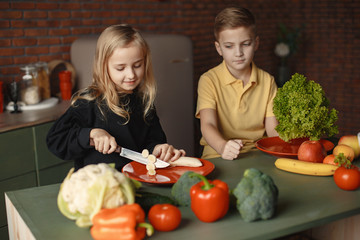 Brother and sister. Children prepare the salad. Kids in the kitchen.
