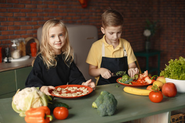 Brother and sister. Children prepare the salad. Kids in the kitchen.