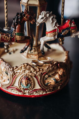 wedding rings lie on a toy carousel with little horses