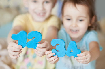 Educational colorful numeral figures in a child hands. Teaching children numbers.
