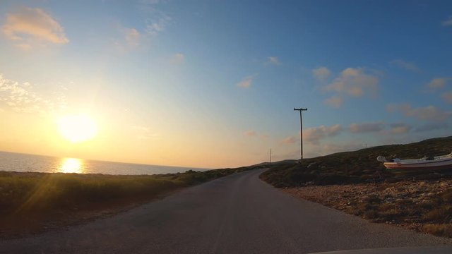 Camera car front pov driving on panoramic road by the sea in Zante at sunset, Greece