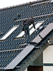 Naklejka premium Installing solar panels on the roof of private house
