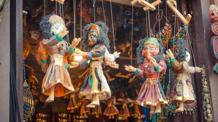 Puppets wearing colourful dress with strings on it