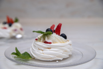 Delicious crunchy meringue cake with fresh berries. Strawberries and blueberries in Anna Pavlova's famous dessert. Popular traditional Russian dessert. Photo for the restaurant menu.