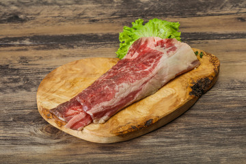 Raw beef bacon over wooden board