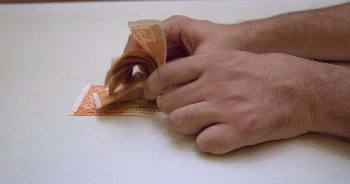 Man counting 5000 bills of Pakistani currency