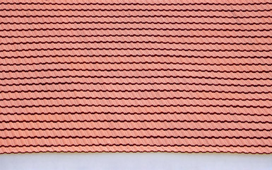 Red roof of a house. Stone coated textured aluminium roofing tiles, mediterranean scalloped style roof design.