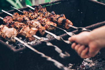 Close up of toasted shashlik on skewers. Succulent barbecue roasting on chargrill. Concept of picnic outdoor.