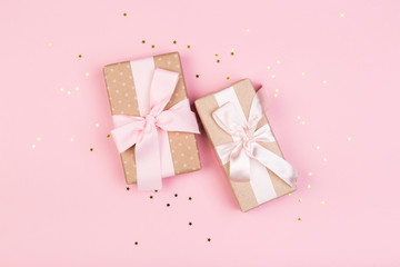 Gift or gift box and stars confetti on a pink table from above. Flat composition for birthday
