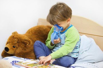 Ein Junge sitzt im Bett und inhaliert