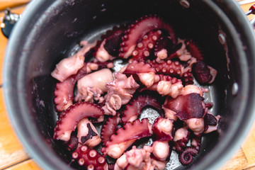 Boiled octopus in a small camping pot. Touristic equipment, hunting and fishing, close up
