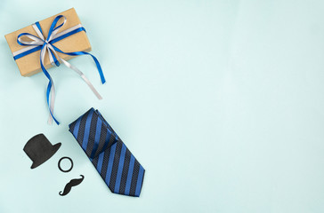  Happy Fathers Day. Gift box and festive decoration on light blue table. Top view, flat lay, copy space