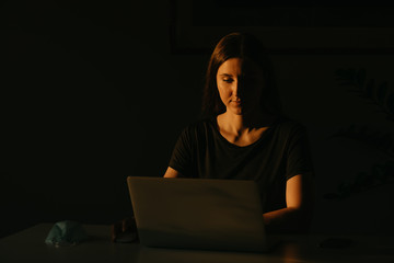 A caucasian woman working remotely on her laptop during the quarantine to avoid the spread...