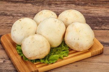 Raw champignons over the board