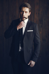 Elegant man in a black suit. Male with cigar