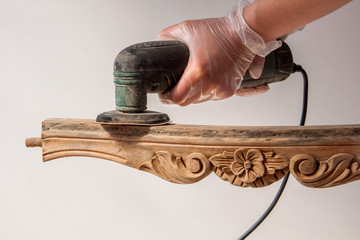 renovation armchair by sanding with orbit sander on chair's details . Renovation of old furniture...