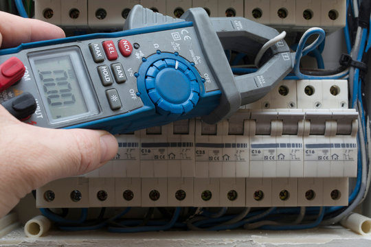 midiendo intensidad en cuadro el&eacute;ctrico de una vivienda con una pinza amperimetrica 