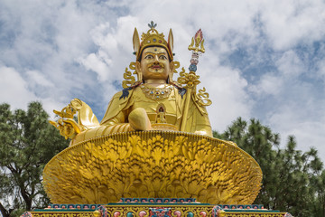 Big golden statue of Indian tantric master Padmasambhava (Guru Rinpoche) on a lotus throne in...