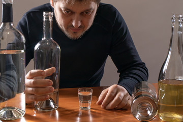 A man with alcohol. Alcoholism, depression and delirium tremens. Alcohol addiction.