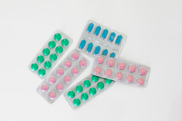 Medical pills in packing laying on white background