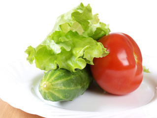 Red tomato green cucumber on a plate. Ingredients for cooking
