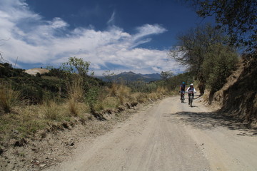 Pareja de ciclistas de montaña en camino de terracería