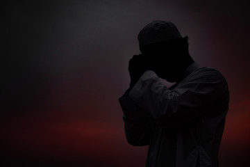 Silhouette Young asian muslim man praying on sunset,Ramadan festival concept