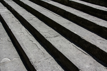 Old stone steps with the vertical faces in deep shadow to form alternating diagonal bands of light and dark stripes