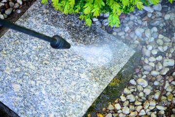 Cleaning with a pressure washer of granite garden slabs, washing with water under high pressure of...