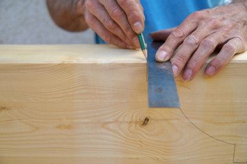Dovetail joint. male Hand of carpenter is measuring angle of Natural Wooden beam. Preparation for cutting  with a saw. Wooden beams spruce for outdoor construction, for carport. woodwork concept. 