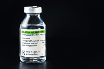 Chloroquine phosphate (generic name, own label design with dummy data - not real product) drug in small vaccine bottle, dark background - Potential coronavirus cure concept