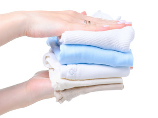 Hand holding baby clothing beige pants on hanger on white background isolation