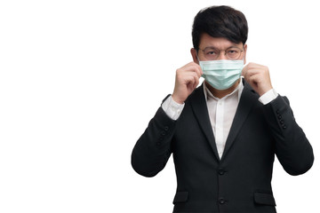 Asian businessman wearing surgical face mask in formal black suit jacket, two hands touch the mask  looking camera, studio light portrait isolated on white background, coronavirus concept, COVID19