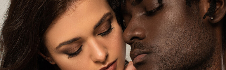 close up of interracial couple isolated on grey, website header