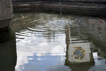 Schwabentor in Freiburg spiegelt sich in einem Brunnen