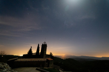 Stars shining begin the church of Sant Miquel de Castelltallat. In the background of the images the mountain of Montserrat. The most famous mountain in Catalonia.