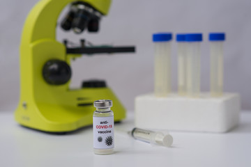Anti-COVID-19 vaccine, microscope and tubes. Landscape orientation. White background.