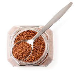 Instant coffee in a glass jar and in a spoon on a white background isolated. The view from top