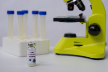 Anti-COVID-19 vaccine, microscope and tubes. Landscape orientation. White background.